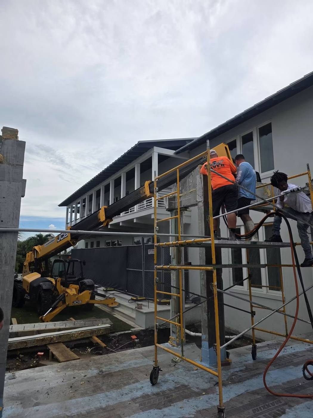 Baker Demolition & Construction crew working on structural framing with a telehandler on site
